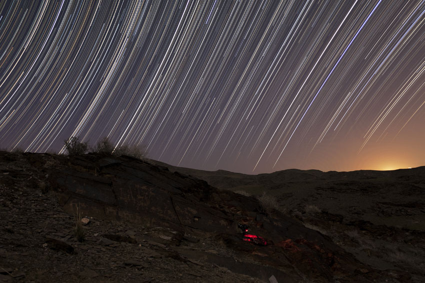 Star Trails Arc Over Ancient Landscape in Photo